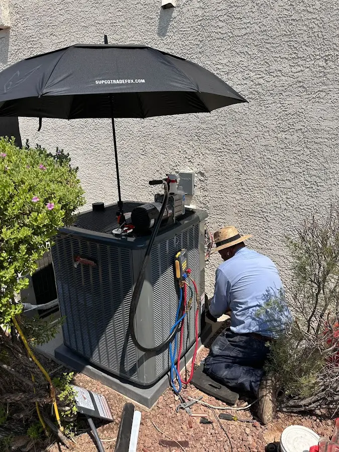 HVAC technician performing outdoor AC maintenance in Franklin Farm