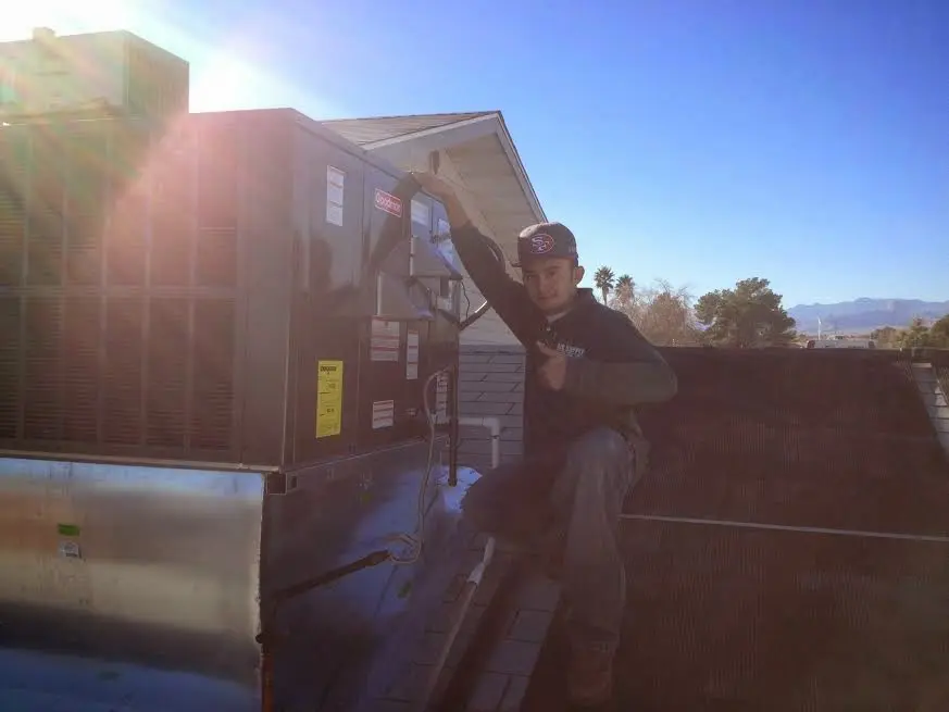 HVAC technician performing Heat Pump Repair on a rooftop unit in Franklin Farm